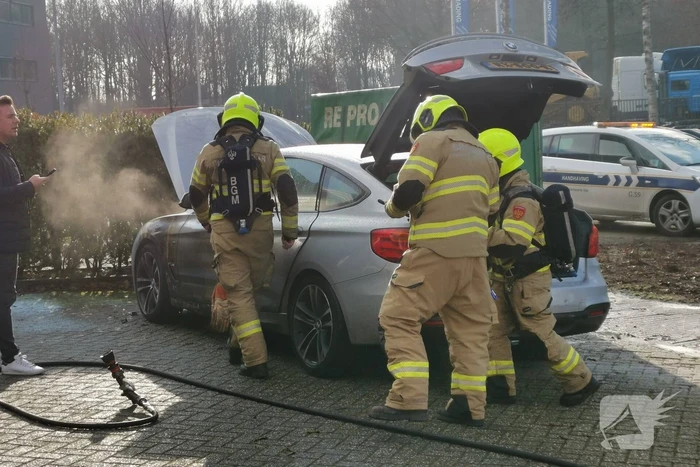 Medewerkers blussen beginnende autobrand