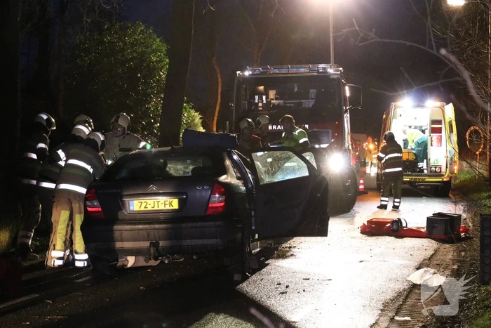 Bestuurder bekneld na botsing op boom