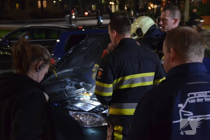 Brandweer inspecteert auto na brand