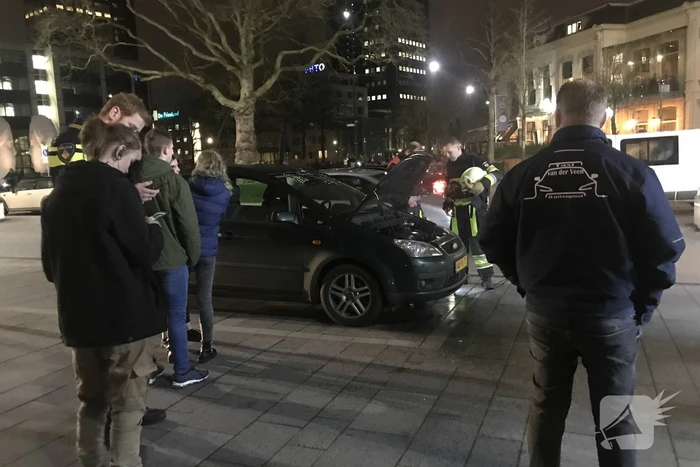 Brandweer inspecteert auto na brand