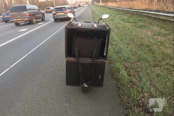Pizzabezorger rijdt met scooter snelweg op