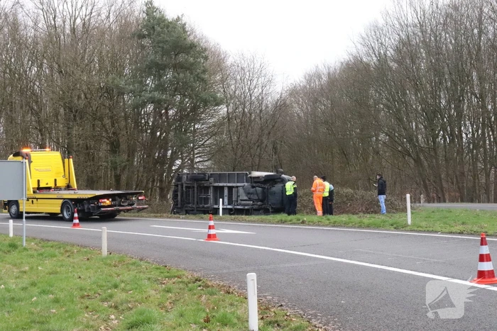 Vrachtwagen belandt op zijn kant op afrit