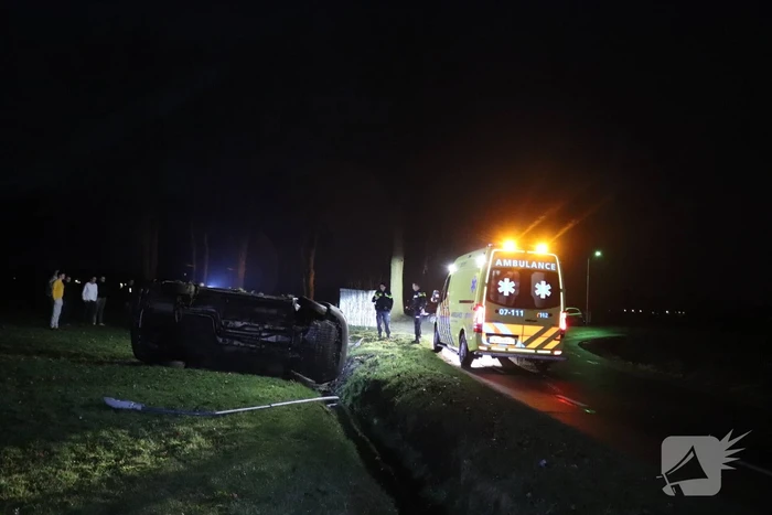 Bestelbus vliegt uit de bocht en belandt op zijkant, twee aanhoudingen