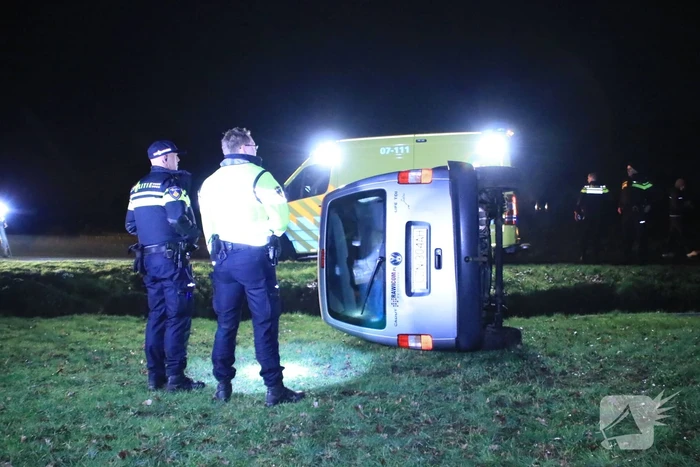Bestelbus vliegt uit de bocht en belandt op zijkant, twee aanhoudingen