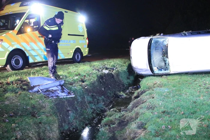 Bestelbus vliegt uit de bocht en belandt op zijkant, twee aanhoudingen