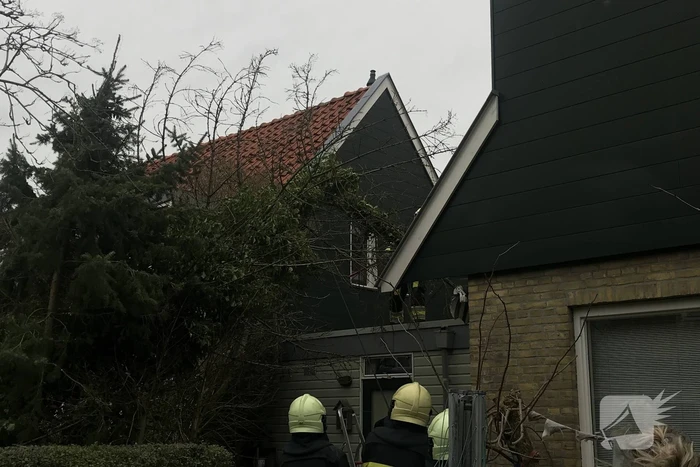 Boom drijgt op schuur te vallen