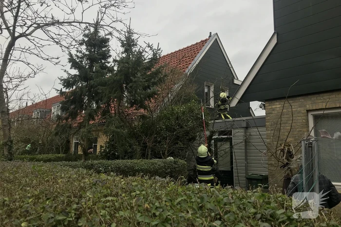 Boom drijgt op schuur te vallen