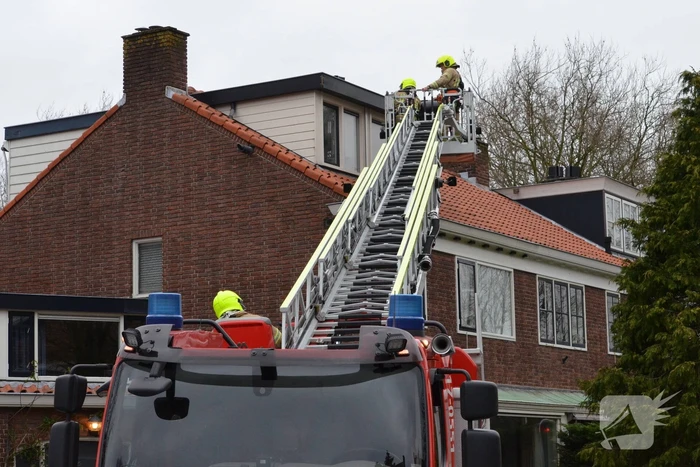 Brandweer zet dakrand vweer vast