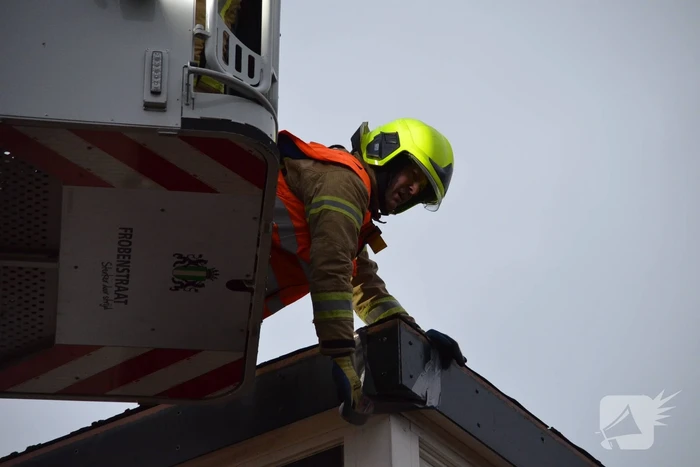Brandweer maakt losgelaten dak vast