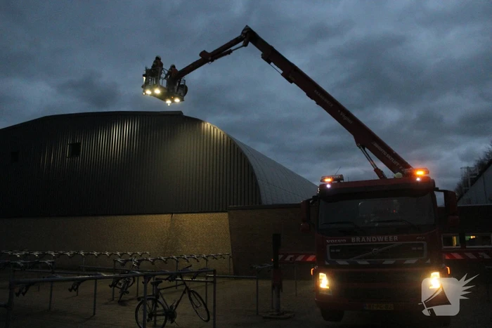 Brandweer verwijderd loshangende dak plaat