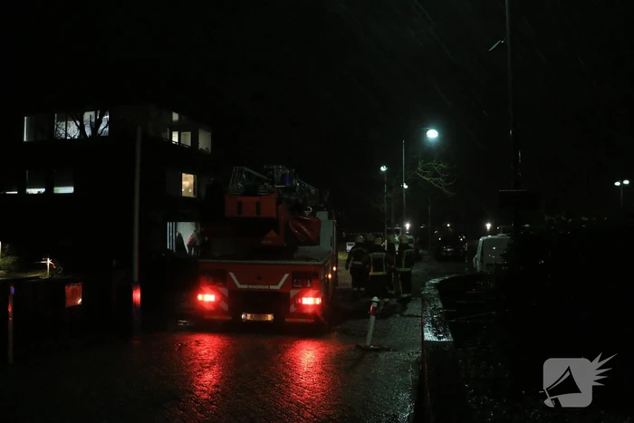 Brandweer druk met losse dakdelen op bedrijfspand