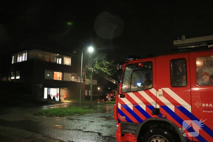 Brandweer druk met losse dakdelen op bedrijfspand