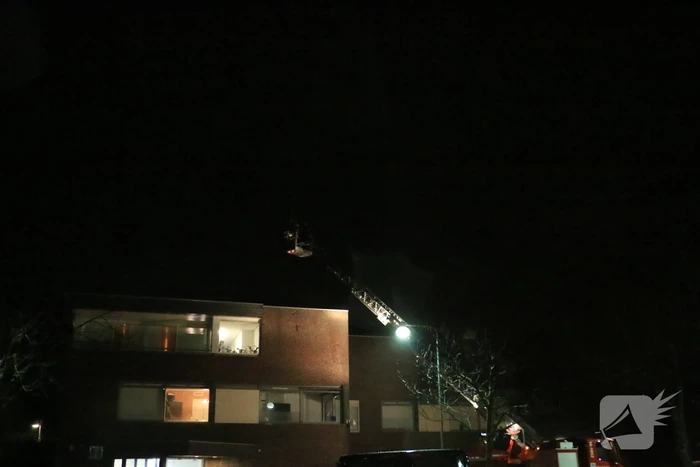 Brandweer druk met losse dakdelen op bedrijfspand