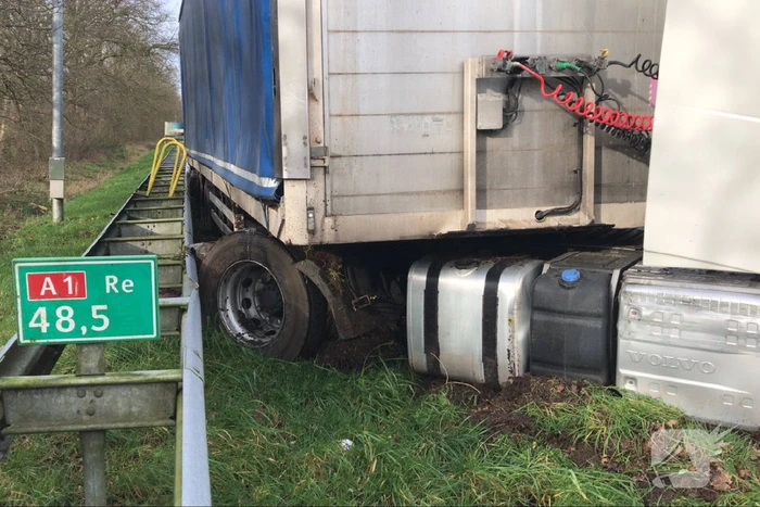 Vrachtwagen belandt in berm tegen vangrail