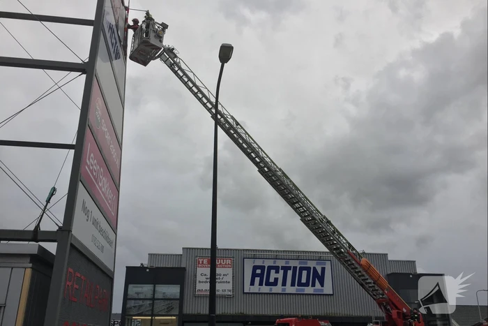 Deel van reclamebord dreigt weg te waaien