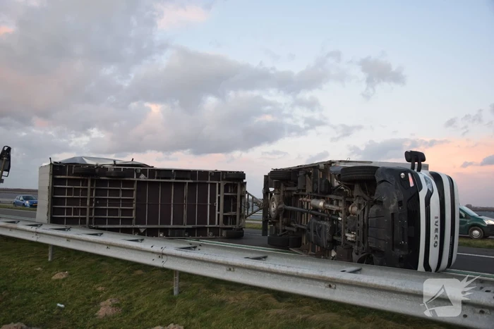 Lege vrachtwagen gekanteld door harde wind op Philipsdam
