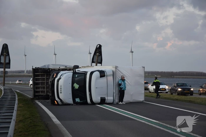 Lege vrachtwagen gekanteld door harde wind op Philipsdam