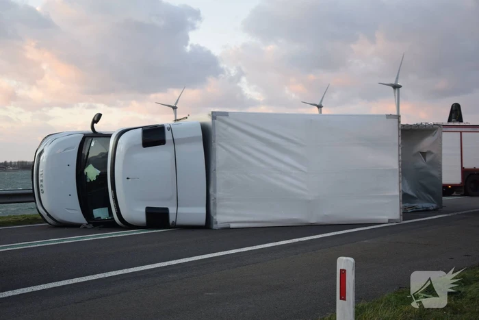 Lege vrachtwagen gekanteld door harde wind op Philipsdam