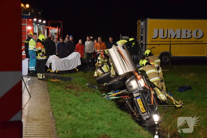 Personenauto belandt op de zijkant in sloot