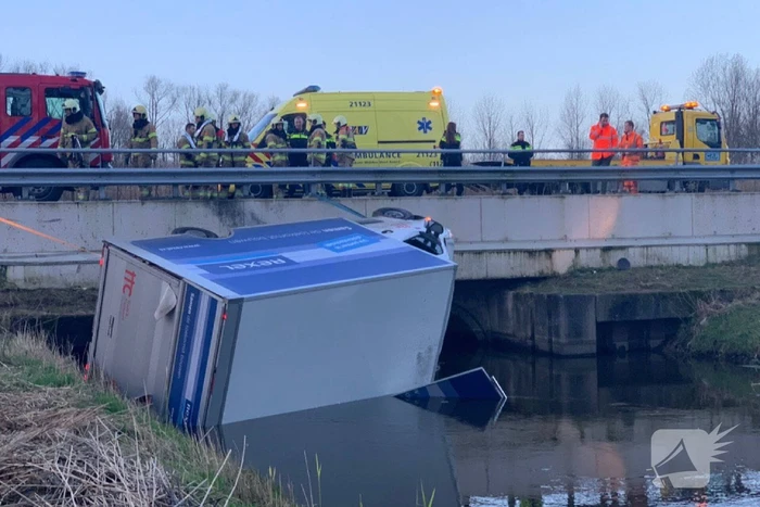 Bestelbus raakt van de weg en belandt te water