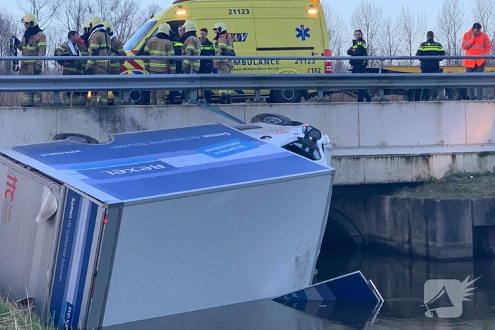 Bestelbus raakt van de weg en belandt te water