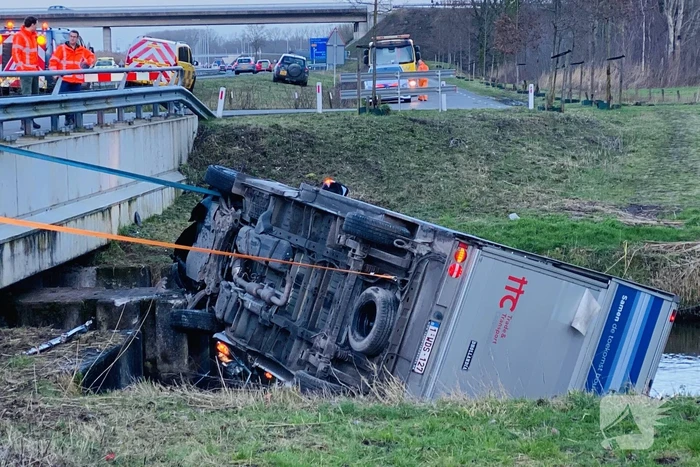 Bestelbus raakt van de weg en belandt te water