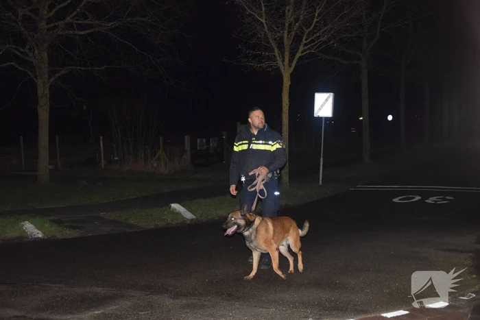 Politieauto en personenauto beschadigd door stenen op rijbaan