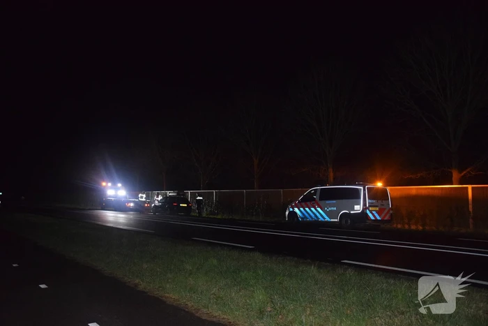 Politieauto en personenauto beschadigd door stenen op rijbaan