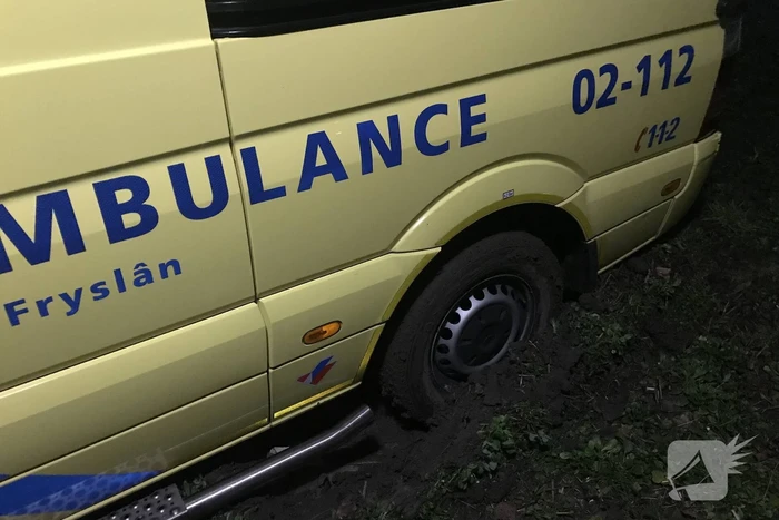Ambulance komt vast te zitten in grasveld