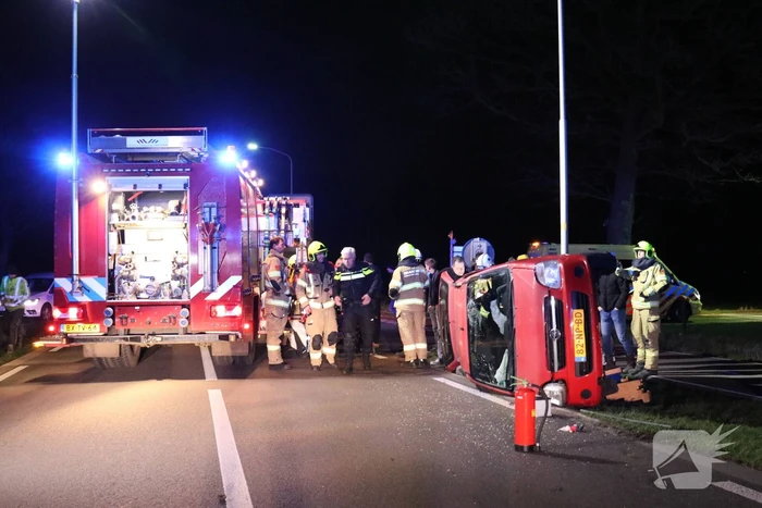 Auto op zijn kant na botsing tegen lantarenpaal