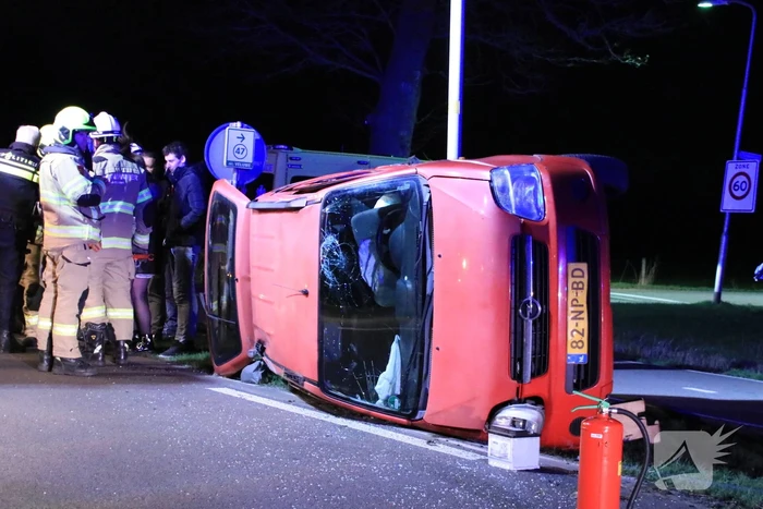 Auto op zijn kant na botsing tegen lantarenpaal