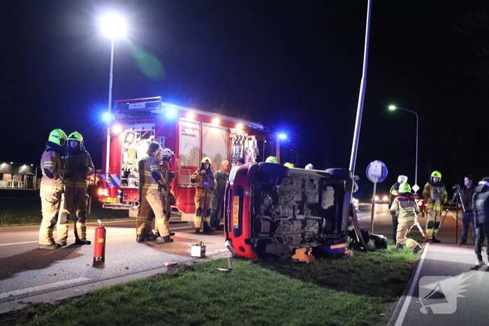 Auto op zijn kant na botsing tegen lantarenpaal