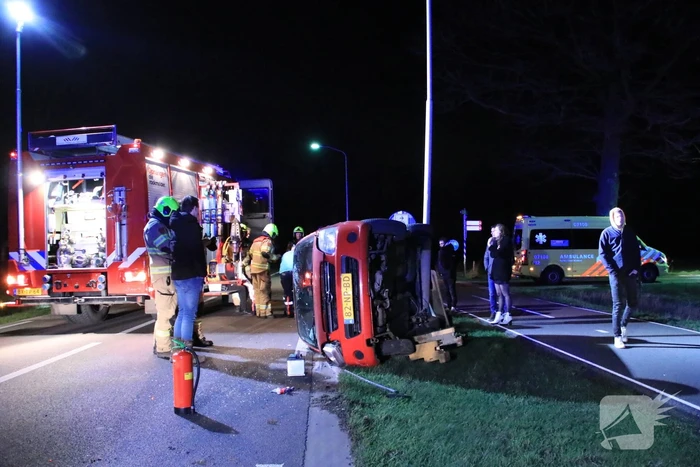 Auto op zijn kant na botsing tegen lantarenpaal