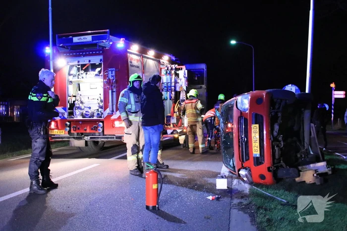 Auto op zijn kant na botsing tegen lantarenpaal