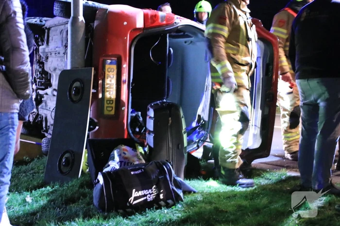 Auto op zijn kant na botsing tegen lantarenpaal