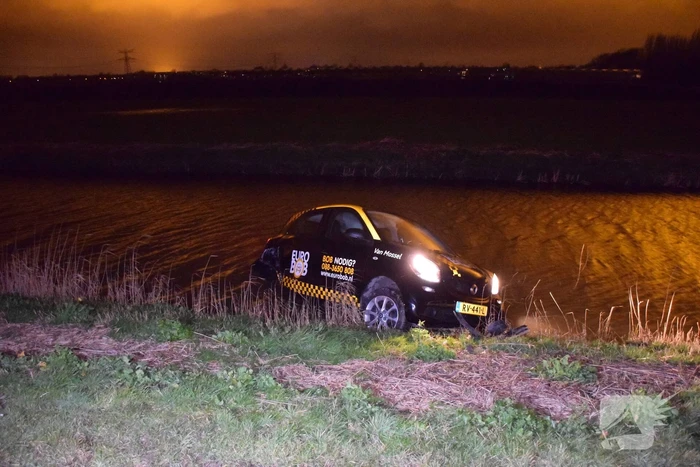 Auto belandt in sloot na botsing met hek