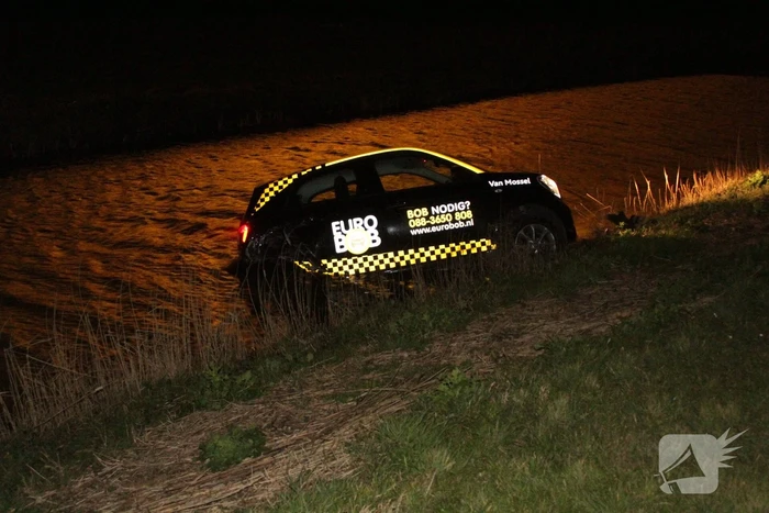 Auto belandt in sloot na botsing met hek