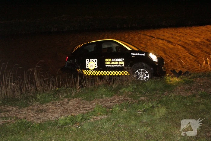 Auto belandt in sloot na botsing met hek