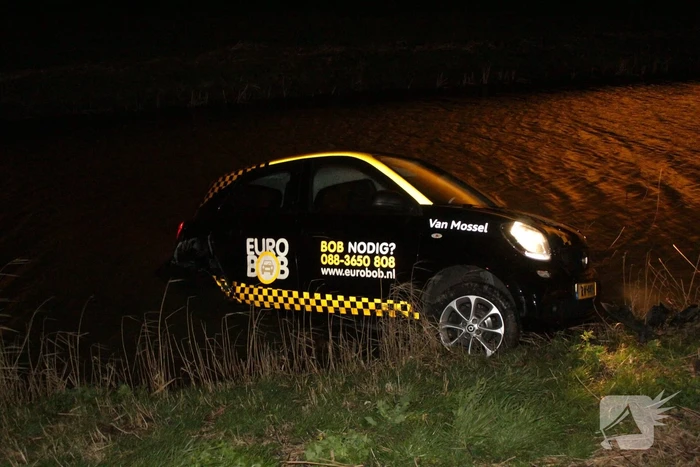 Auto belandt in sloot na botsing met hek