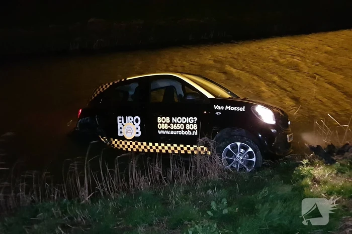Auto belandt in sloot na botsing met hek