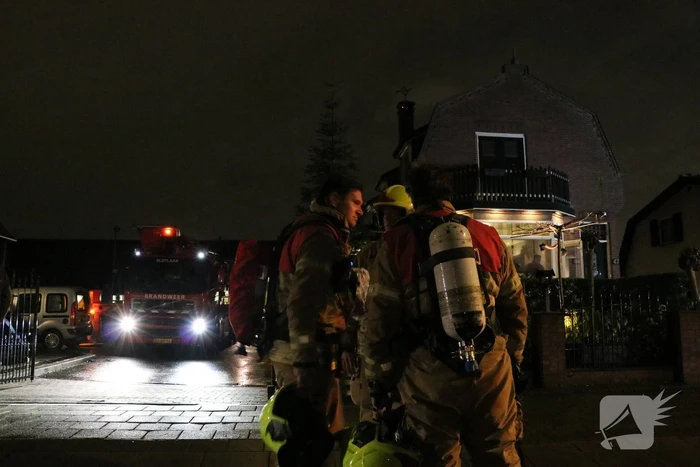 Vlammen slaan uit schoorsteen van woning