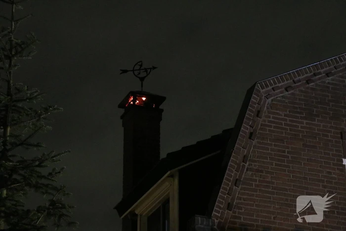 Vlammen slaan uit schoorsteen van woning
