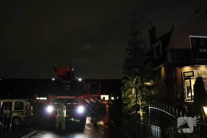 Vlammen slaan uit schoorsteen van woning