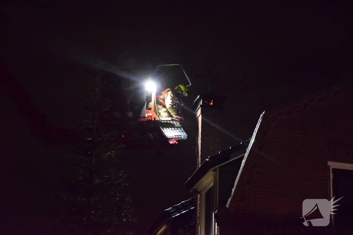 Vlammen slaan uit schoorsteen van woning