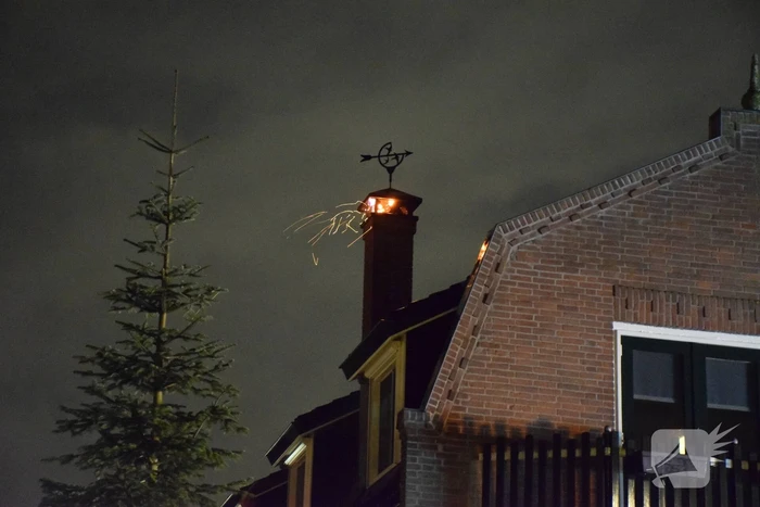 Vlammen slaan uit schoorsteen van woning