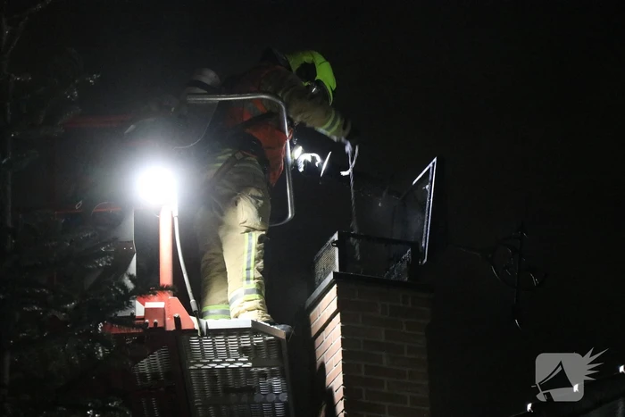 Vlammen slaan uit schoorsteen van woning