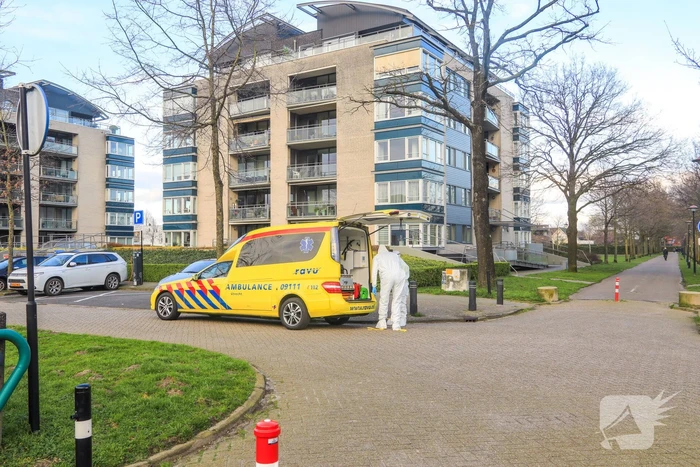 Mannen in witte pakken halen vermoedelijke coronapatiënt uit huis