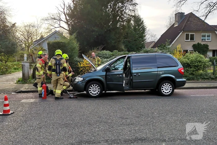 Rook onder de motorkap van de auto