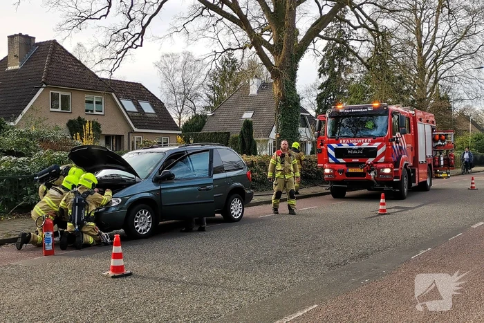 Rook onder de motorkap van de auto