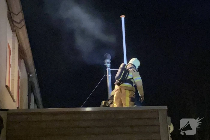 Brand in schoorsteenpijp van palletkachel achter woning